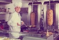 Man cook making kebab dish on kitchen in fast food restaurant Royalty Free Stock Photo