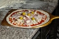 Man cook pizza, pizza on a pizza shovel. Chef taking raw pizza on metal shovel for baking in the oven in traditional restaurant Royalty Free Stock Photo