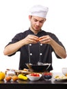 A large young guy, the chef, breaks the egg into a black plate. Royalty Free Stock Photo