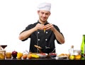 A large young guy, the chef, breaks the egg into a black plate. Royalty Free Stock Photo