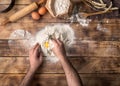 Man cooking bread dough on wooden table in bakery