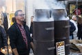 Man cooking chestnuts in Porto, Portugal. Smoke coming out of the chestnut oven