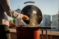 Man cooking a dish in a barbecue grill equipped with cooking too