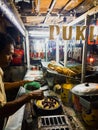 Man cooking a fluffy pancake called martabak in a street food stall