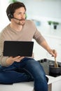 man cooking on kitchen with laptop while talking phone Royalty Free Stock Photo