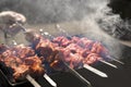 Man cooking marinated shashlik, lamb meat grilling on metal skewer. White smoke. Sale. Close up. Defocused Royalty Free Stock Photo