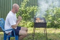 Man cooking meat on barbecue. Young couple making barbecue in their garden. Man cooking meat on barbecue Royalty Free Stock Photo