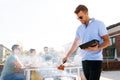 Man cooking meat on bbq at rooftop party Royalty Free Stock Photo