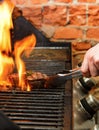 Man cooking meat steaks on professional grill outdoors Royalty Free Stock Photo