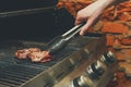 Man cooking meat steaks on professional grill outdoors Royalty Free Stock Photo