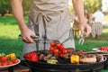 Man cooking meat and vegetables on grill outdoors, closeup Royalty Free Stock Photo