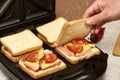 a man cooking sandwiches in a sandwich maker puts a piece of bread in a mold Royalty Free Stock Photo