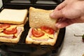 a man cooking sandwiches in a sandwich maker puts a piece of bread in a mold Royalty Free Stock Photo