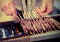 man while cooking skewer called ARROSTICINI in Italian language