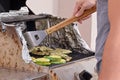 Man cooking steaks and zucchini medallions are cooked on gas-grill grate Royalty Free Stock Photo