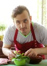 Man cooking vegetable salad (tomatoes, lettuce, cucumbers) Royalty Free Stock Photo