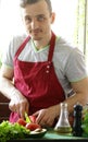 Man cooking vegetable salad (tomatoes, lettuce, cucumbers) Royalty Free Stock Photo