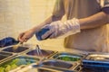 The man is cooking Vietnamese Pork Banh Mi Sandwich in a black baguette