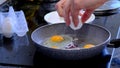 man cooks fried eggs in a teflon pan, pour refined palm oil into the pan. Cooking process of tasty healthy food. Royalty Free Stock Photo