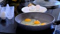 man cooks fried eggs in a teflon pan, pour refined palm oil into the pan. Cooking process of tasty healthy food. Royalty Free Stock Photo