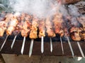 man cooks many shish kebabs on outdoor brazier