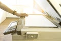 Man is copying document from a Photocopier with access control of scanning key card panel.