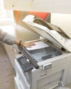 Man copying document from Photocopier with sunlight from window Royalty Free Stock Photo