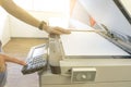 Man copying paper from Photocopier with access control for scanning key card sunlight from window Royalty Free Stock Photo