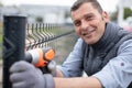 Man cordless-drill erecting wire fence Royalty Free Stock Photo