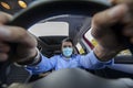 Man with corona mask driving car photographed behind the wheel Royalty Free Stock Photo