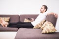 Man on the couch watching tv, changing channels at sofa Royalty Free Stock Photo