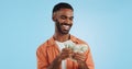 Man, count money and happy in studio with success, bonus or dollar promotion with winning by blue background. Investor Royalty Free Stock Photo