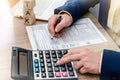 Man counting on calculator and filing 1040 form.