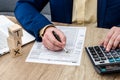 Man counting on calculator and filing 1040 form.