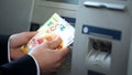 Man counting euros withdrawn from ATM, 24h service, easy banking operation