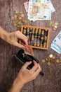 Man counting money with abacus on wooden background, top view. Financial concept