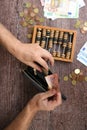 Man counting money with abacus on wooden background, top view. Financial concept