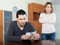 Man counting money, wife watching