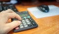 A man counts on a calculator, uses his fingers to press Royalty Free Stock Photo