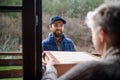 Man courier delivering parcel box to senior woman. Royalty Free Stock Photo