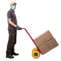 Man courier with mask uses a handtruck to transport packages