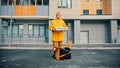 Man courier in yellow clothes delivers food - holding pizza boxes