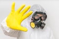 Man in coveralls with gas mask is showing stop gesture Royalty Free Stock Photo
