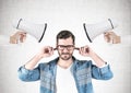 Man covering ears, two loudspeakers Royalty Free Stock Photo