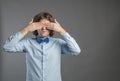 Man covering his eyes with hands on gray background. Shy male closing eyes by hands can `t see hiding, wall background. See no evi