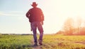 A man cowboy hat and a loso in the field. American farmer in a f