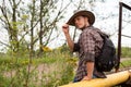 A man in a cowboy hat sits on a gas pipe