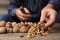 Man cracking walnuts at wooden table, closeup Royalty Free Stock Photo