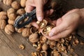 Man cracking walnuts at wooden table, closeup Royalty Free Stock Photo