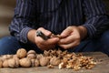 Man cracking walnuts at wooden table, closeup Royalty Free Stock Photo